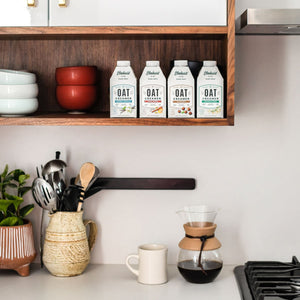 Elmhurst's varieties of shelf-stable oat milk coffee creamers sitting on a shelf